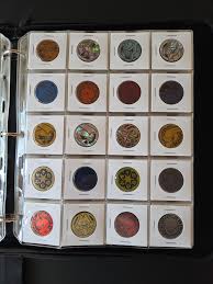 Cómo conservar monedas antiguas: guía definitiva para coleccionistas Álbum de colección numismática con compartimentos azules para guardar monedas correctamente