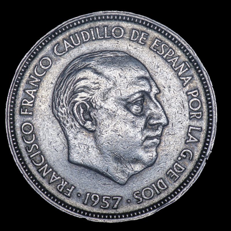 Cabeza de Francisco Franco mirando a la derecha con la leyenda de su título y la fecha fija de 1957.